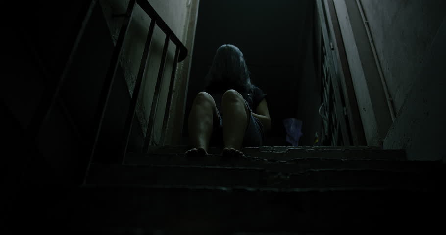 Horror scene of a mysterious Scary Asian ghost woman creepy have hair covering the face sitting on staircase at abandoned house with background dark scene movie at night, festival Halloween concept Royalty-Free Stock Footage #1107333721