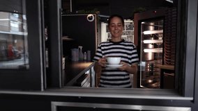 Portrait of a smiling Caucasian waitress, giving pickup order, holding a takeaway coffee cup - Powered by Shutterstock - Get 15% off with code: PIKWIZARD15