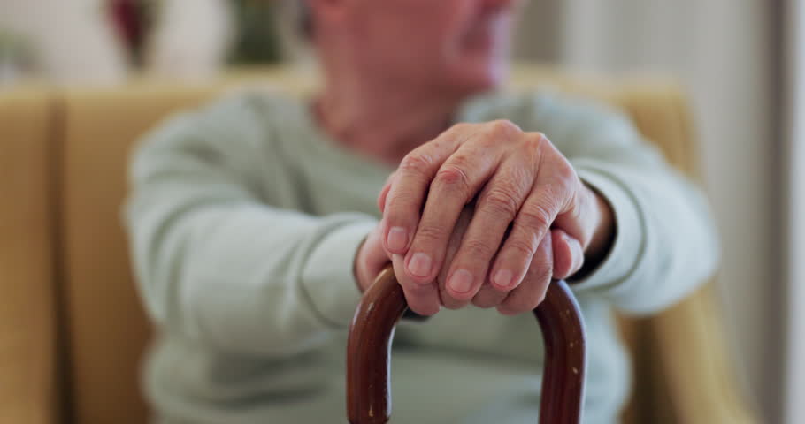 Elderly man, walking stick and hands on wood cane for balance, support or mobility in retirement or nursing home. Senior patient, closeup and old person with a disability or arthritis aid on sofa Royalty-Free Stock Footage #1107335643
