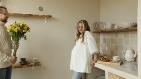 A man gives a bouquet of yellow flowers to his pregnant wife - Powered by Shutterstock - Get 15% off with code: PIKWIZARD15