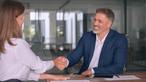 Mature Latin business team of woman and European business man shaking hands as colleagues, partners or employees, signing a contract. Group of people satisfied with results of team work together. - Powered by Shutterstock - Get 15% off with code: PIKWIZARD15