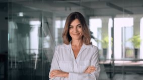 Beautiful hispanic senior business woman with crossed arms smiling at camera. European or latin confident mature good looking middle age leader female businesswoman on office background, copy space. - Powered by Shutterstock - Get 15% off with code: PIKWIZARD15