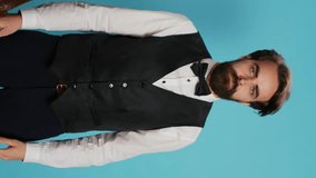 Vertical video Hotel concierge does timeout symbol in studio, asking for a break working in hotel and tourism industry. Elegant doorkeeper in formal attire indicating pause gesture with hands - Powered by Shutterstock - Get 15% off with code: PIKWIZARD15
