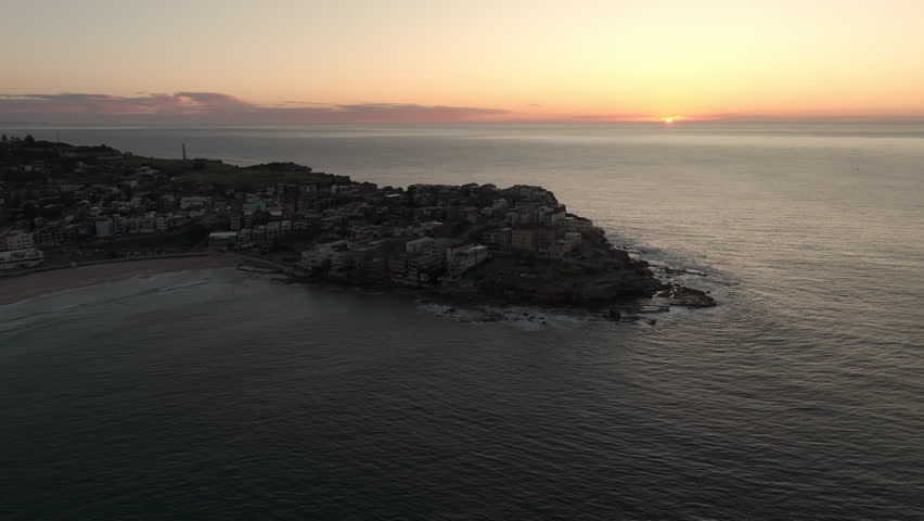 Drone aerial point of view cityscape skyline skyscrapers and village community people house by ocean coastline beach at NSW, Australia at sunrise. Landmark famous place and beauty nature concept. Royalty-Free Stock Footage #1107342975