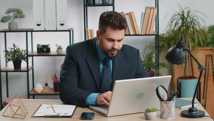 Irritated tired Caucasian business man while working on laptop, unexpected online website problem, computer virus data loss by hacking. Freelancer feeling mad about broken notebook at office workplace Royalty-Free Stock Footage #1107347887