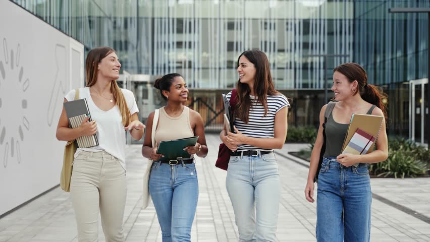 College friends walking in the University campus - Young Hispanic and African American Women Students Royalty-Free Stock Footage #1107355345