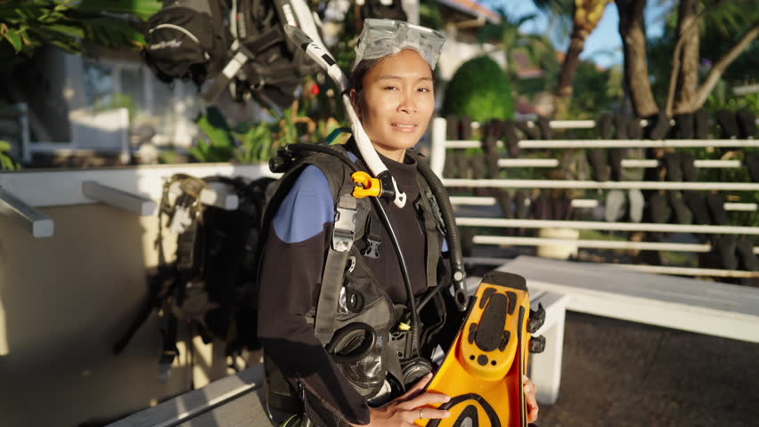 Dolly in, portrait of asian woman scuba diver in dive center, smiling face