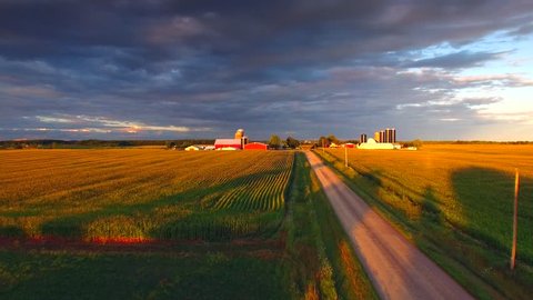 The American Heartland At Sunset. A country road, corn fields, farms and a dramatic sky conspire to make a uniquely beautiful landscape.