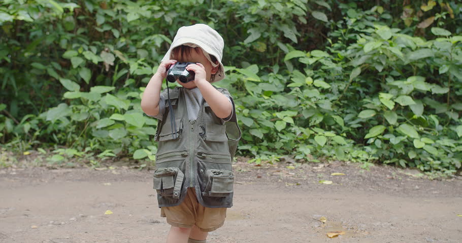 Happy Tourist cute little Asian toddler daughter kid girl using binoculars watching animals in the forest natural background, adventure explorer camping travel trip Learning about Nature Royalty-Free Stock Footage #1107362823