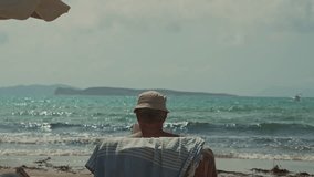 Corfu island, Greece - 2023.07.01 - 09: Elderly man enjoying a book on a sunbed at the beautiful beach, under the hot, sunny blue sky, with gentle waves in the blue water background - Powered by Shutterstock - Get 15% off with code: PIKWIZARD15
