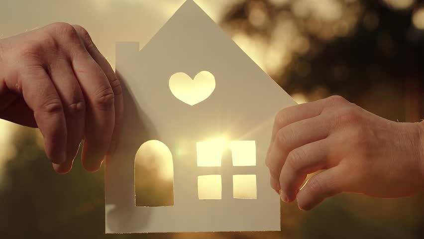 Dreaming of buying house. Real estate insurance. Hands of family hold paper house at sunset in park, sun shines through window. Symbol of home, happiness. Concept of building house for family, child. Royalty-Free Stock Footage #1107368425
