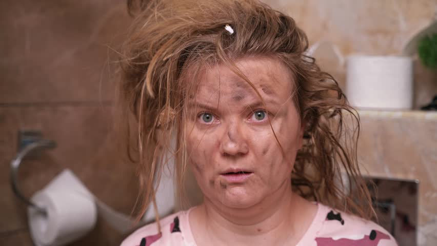 Portrait of shocked dumbfounded woman in pajamas sitting in toilet with her hair on end, face covered in soot from explosion smeared with mud blinks eyes Unfortunate childish prank April Fools Day.  Royalty-Free Stock Footage #1107374105
