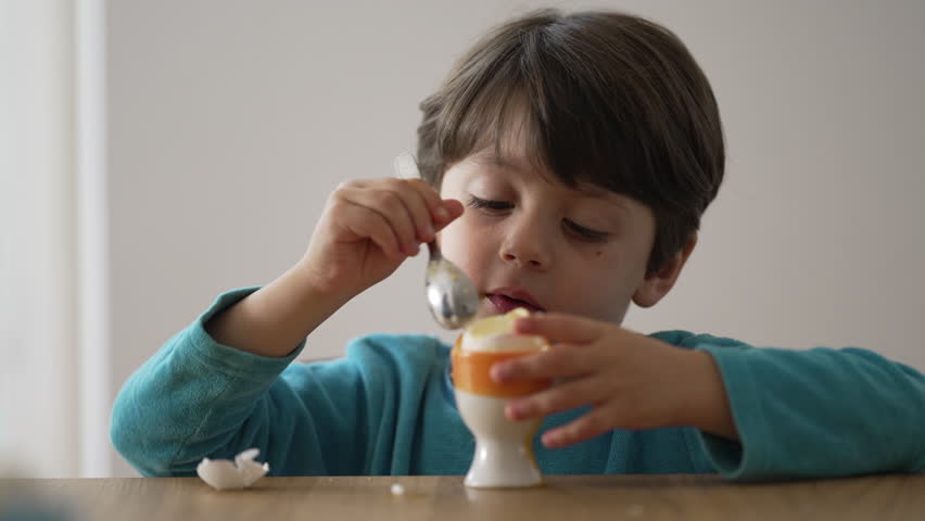 Child Savoring Soft Boiled Egg, Indulging in a Healthy Bite Royalty-Free Stock Footage #1107379117