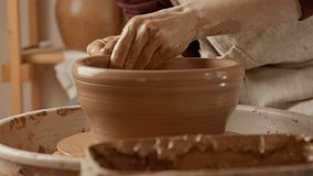 Potter making ceramic plate or dish on pottery wheel. Two hands create bowl. Potter shapes clay product. Close-up in 4K, UHD - Powered by Shutterstock - Get 15% off with code: PIKWIZARD15