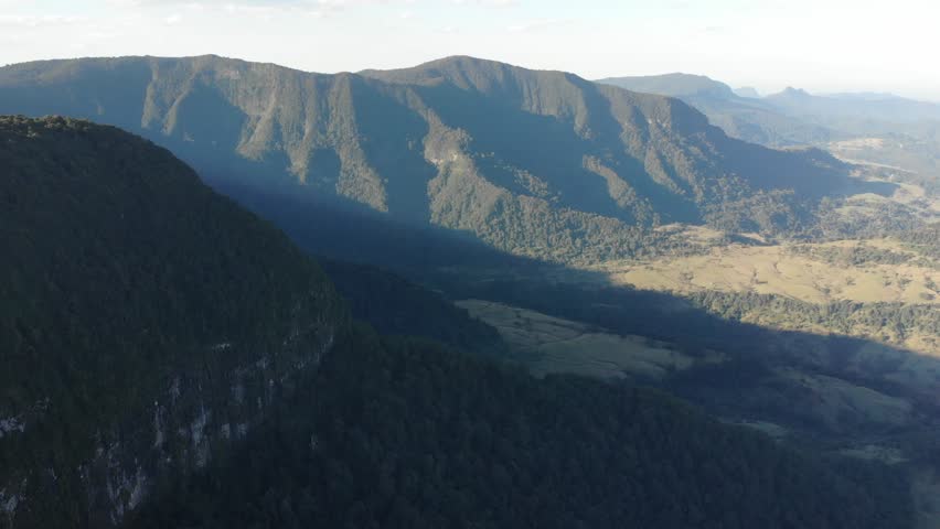 aerial drone panorama of green mountains in lamington national park near gold coast, queensland, australia; flying above ancient gondwana rainforest during sunset
