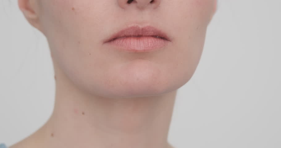 Close up, woman pushing chin forward, pushes back. Remove second chin. Beautiful caucasian oval face. Natural youth on white background. European facial beauty. Face skin rejuvenation. Skin care video | Shutterstock HD Video #1107397155