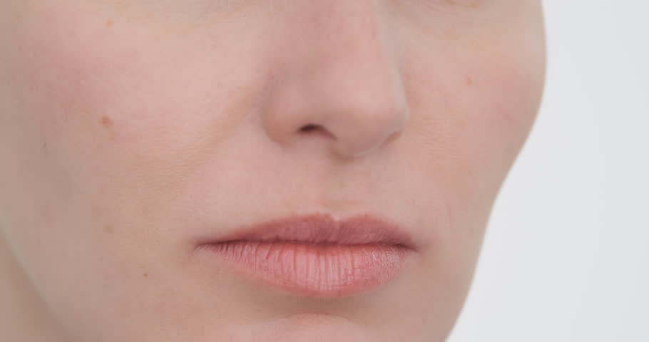 Close up, woman sniffing smelly smell with her nose. Caucasian woman crop face breathe on white background. Closeup female nose inhales, sniff bad smells. Disgusting smell, odor. Person have allergic Royalty-Free Stock Footage #1107397159