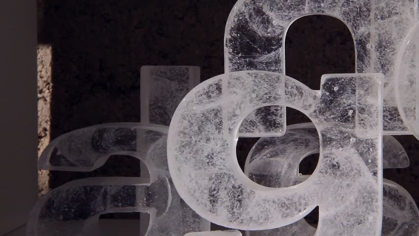 panning right close up shot of different light letters made of glass, looks as if they are made of ice