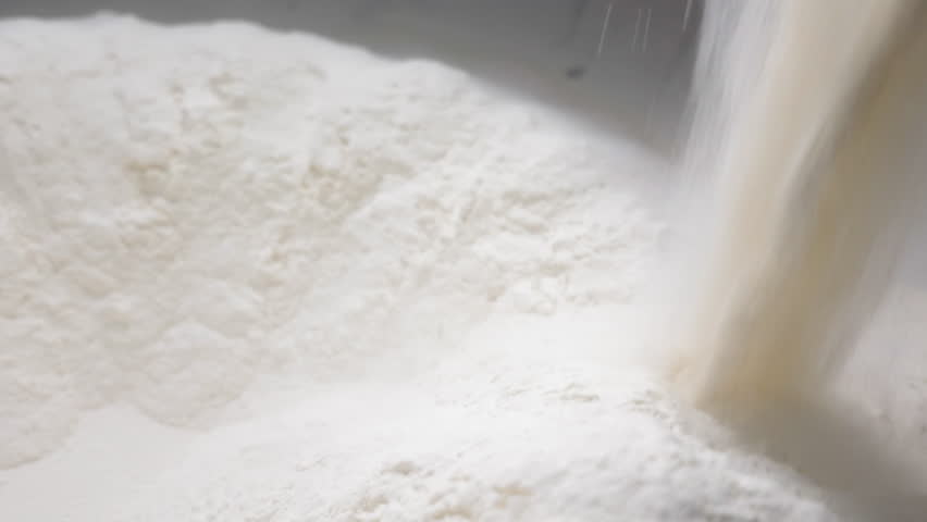 Process of sifting Flour for making Dough in Bakery. Measured Amount of Flour being poured into Large Mixing Bowl through Electrical Sifter Machine. Concept of making Bread Royalty-Free Stock Footage #1107402565