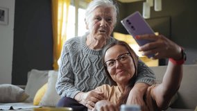 Smiling granddaughter taking selfie photo with her cheerful grandmother at home using phone - Powered by Shutterstock - Get 15% off with code: PIKWIZARD15