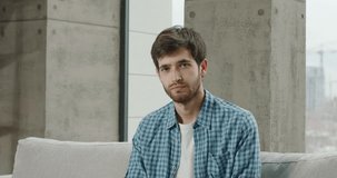 Video conference chat with young man. Concentrated Caucasian man facing webcam nodding head, smiling laughing. Bearded hipster man looking at camera and nodding yes, approving, body language concept.