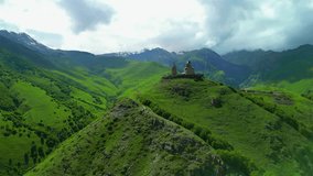 kazbegi trinity church among the green mountains view from a flying drone - stock video georgia stepantsminda