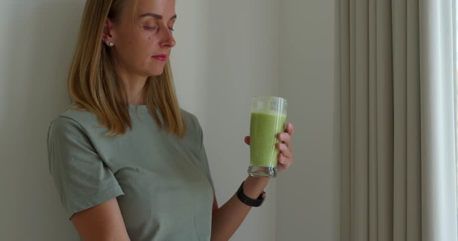 Attractive fit woman in sport uniform drinking smoothies