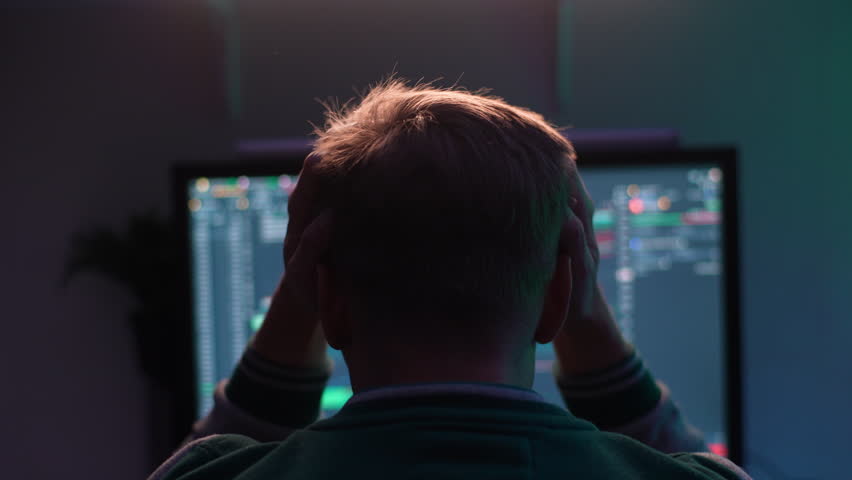 Back view of unrecognizable anxious male stock trader tearing out hair from despair watching real-time stocks, exchange market charts on monitor. Man works remotely in investment at home office. Royalty-Free Stock Footage #1107410847