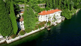 Aerial 4K footage of touristic villa Monastero located in Varenna resort, on the shore of lake Como, Italy