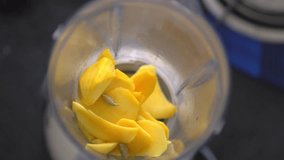 Sharp splash of mango shake. Preparation of healthy organic mango fruit milkshake, smoothies from mango, milk cream,video,120fps,4k. Slow motion. Top view of sharp splash mango milk shake healthy.