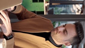 Successful young adult entrepreneur businessman working on laptop from patio cafeteria. Business and people concept. Vertical video footage screen view. - Powered by Shutterstock - Get 15% off with code: PIKWIZARD15