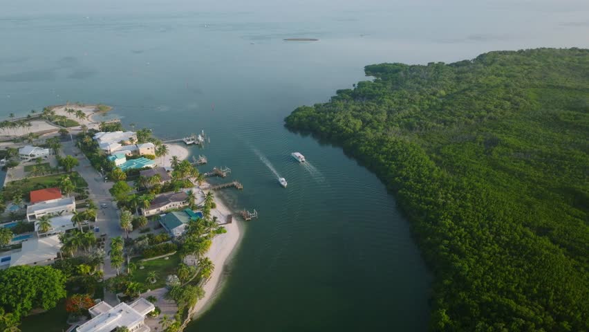 Boats moving through Sombrero Beach canal with waterfront houses in Florida Keys