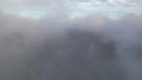An aerial view over clouds in the morning on Storm King Mountain, located on the west bank of the Hudson River in NY. The camera dolly out and boom down revealing the mountains and a two lane road. - Powered by Shutterstock - Get 15% off with code: PIKWIZARD15