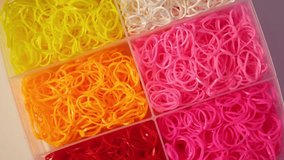 Elastic Loom bands in plastic containers, top view. Rubber Bands Refill Loom set. Bracelet making Kit for kids. 4K Video, Rotating.