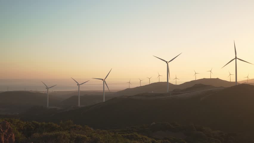 Wind generators in Tarifa, Southern Spain during orange glow sunset light renewable energy