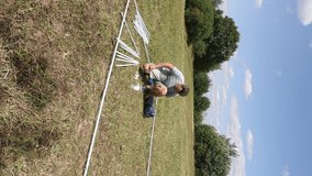 A man connects the elements of the tent with a mosquito net. Assembling the frame of the garden tent. vertical video. - Powered by Shutterstock - Get 15% off with code: PIKWIZARD15