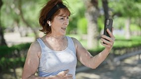 Middle age woman smiling confident having video call at park