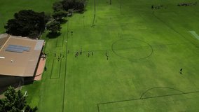 Soccer players entering Perth city field in Australia for amateur football match. Aerial drone circling view