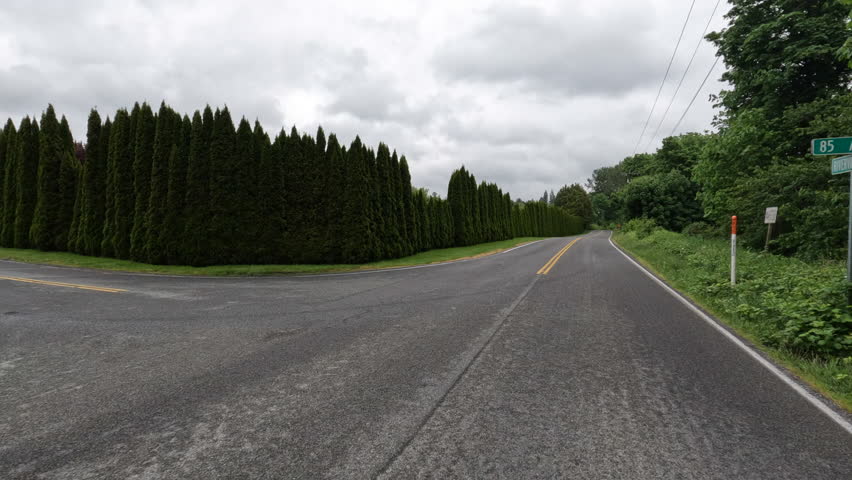 Point of View of Bicyclist Riding Down a Paved Country Road on an Overcast day