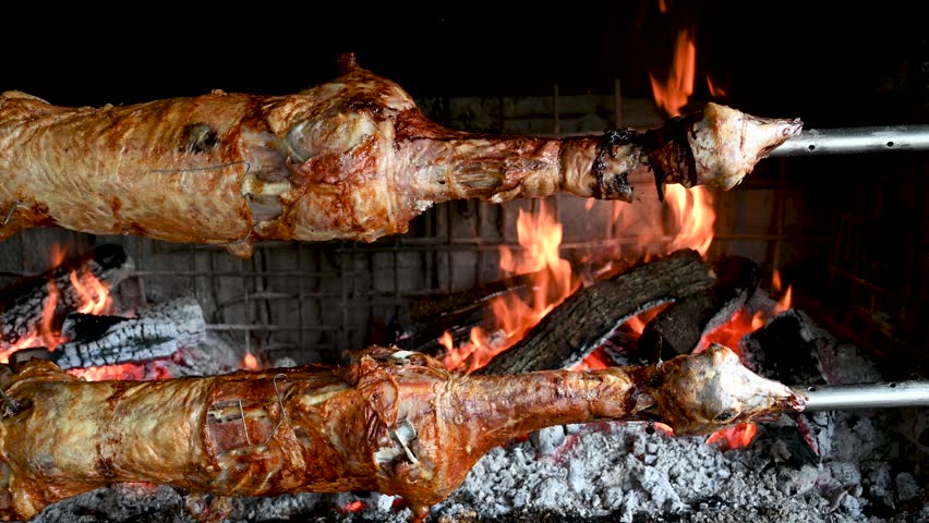 Roasted lamb. Sheep on a spit above fire in a restaurant. Roasted meat. Royalty-Free Stock Footage #1107460757