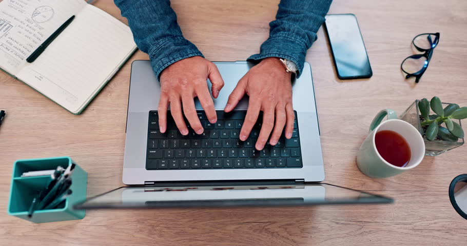 Business person, hands and laptop for planning, website design and marketing research at office desk above. Worker or graphic designer typing on computer keyboard for social media branding and goals
