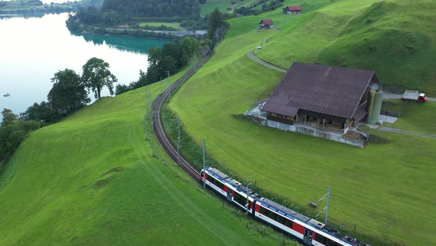 Lush Swiss landscape with commuter train and lake, Lungern, Obwalden, Switzerland Royalty-Free Stock Footage #1107468185
