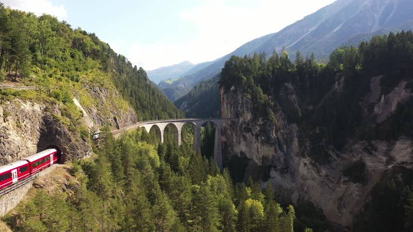 Landwasser viaduct in the Davos mountains near Filisur. Beautiful old stone bridge with a moving train. Spring Time Royalty-Free Stock Footage #1107468197