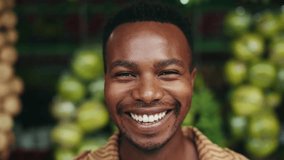 Portrait of Young Black Man Looking at Camera on Fruit Market Background. One Smiling Face and Beautiful Eyes of Happy Male Person Outdoors. Optimism of African American Boy Standing on City Street - Powered by Shutterstock - Get 15% off with code: PIKWIZARD15