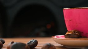 Pink coffee mug and chestnuts on wooden table in front of fireplace - Powered by Shutterstock - Get 15% off with code: PIKWIZARD15