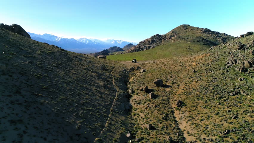 Aerial Backward Shot Of Vehicle On Mountain Against Sky, Drone Flying Over Scenic Landscape - Alabama Hills, California