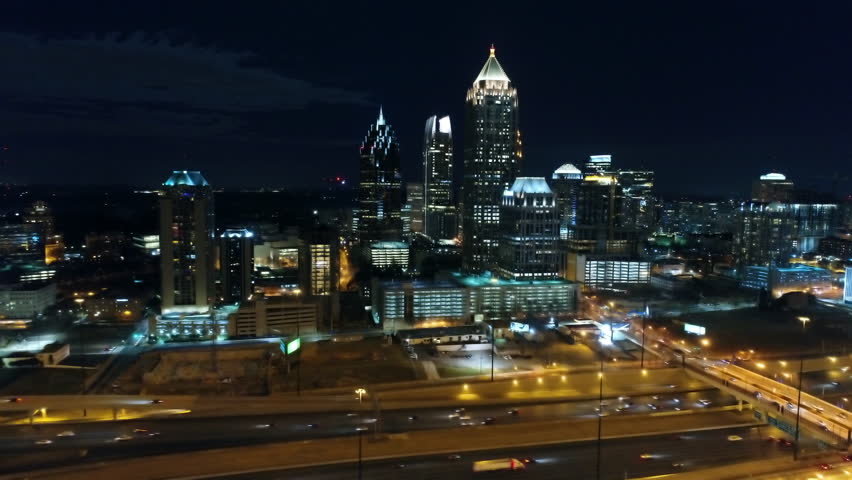 Aerial Panning Shot Of Vehicles On Illuminated Roads By Buildings, Drone Flying Over City Against Sky At Night - Atlanta, Georgia