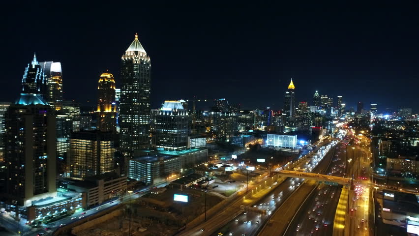 Aerial Shot Of Vehicles On Freeway Near Buildings At Night, Drone Flying Forward Over City Against Sky - Atlanta, Georgia
