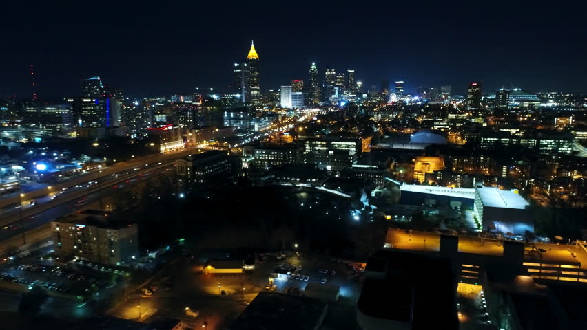 Aerial Panning Shot Of Illuminated Buildings Amidst Streets In City, Drone Flying Over Modern Structures At Night - Atlanta, Georgia