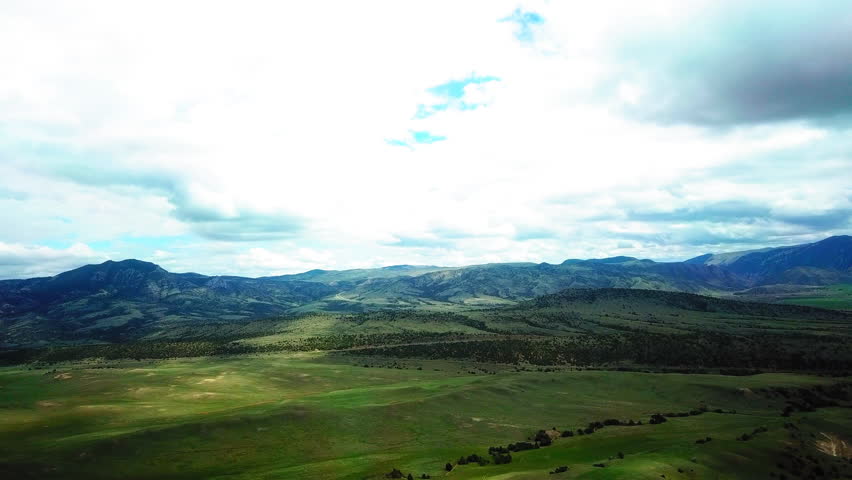 Aerial Shot Of Green Plants And Trees Near Mountain Ranges Against Cloudy Sky - Billings, Montana